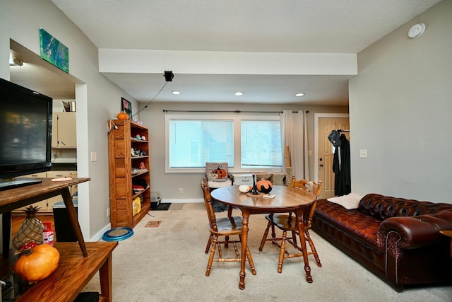 carpeted dining area featuring a textured ceiling