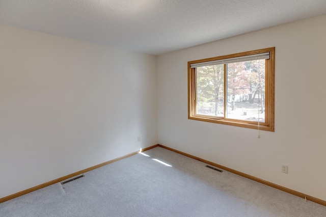 spare room with a textured ceiling and carpet