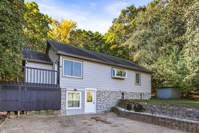 rear view of house with a patio and a storage unit