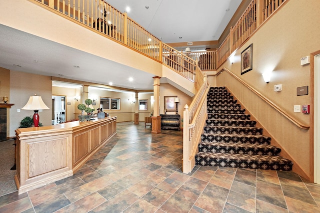 stairs featuring decorative columns and a towering ceiling