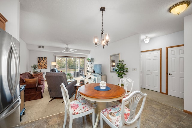 dining space featuring a textured ceiling, dark carpet, and ceiling fan with notable chandelier