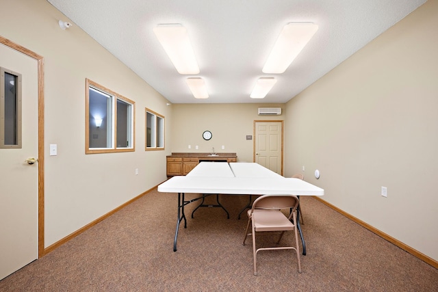 carpeted office space with a wall mounted AC and sink