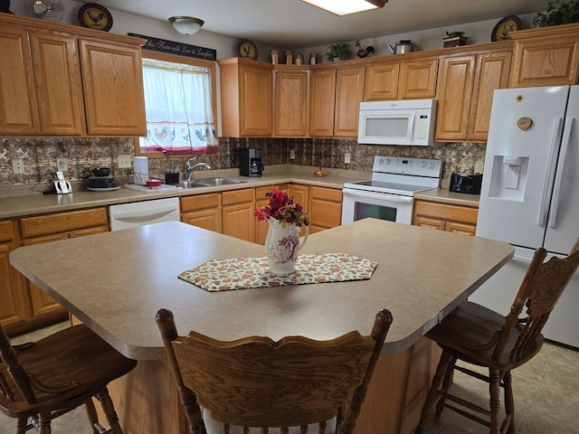 kitchen with white appliances, sink, a kitchen island, and a kitchen breakfast bar