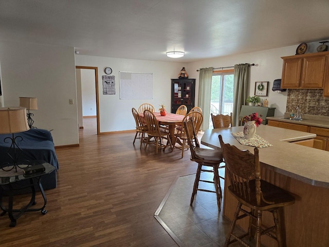 dining space with sink and dark wood-type flooring