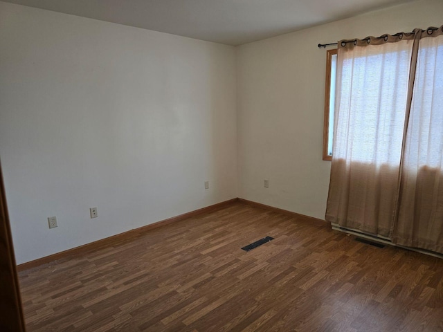 spare room with dark wood-type flooring