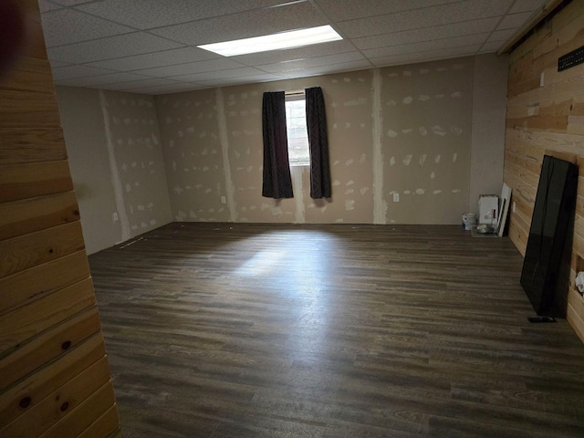 interior space with a drop ceiling and dark hardwood / wood-style flooring