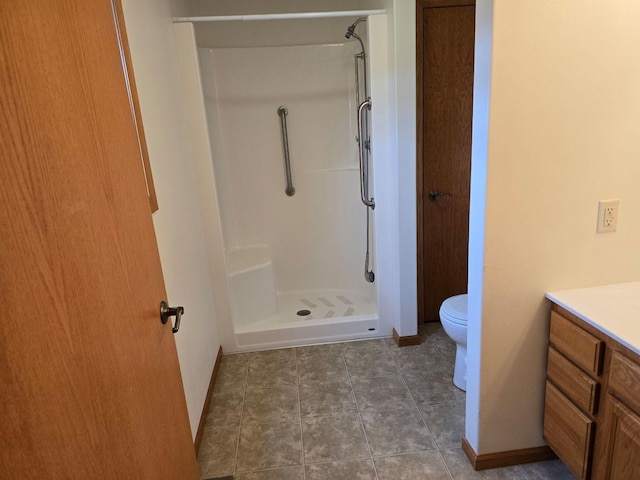 bathroom with toilet, walk in shower, vanity, and tile patterned floors