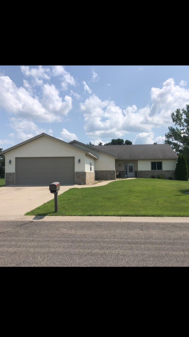 ranch-style home featuring a front lawn and a garage