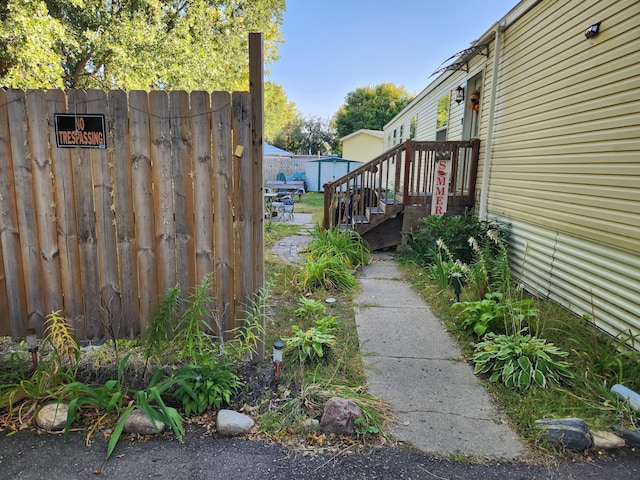 view of side of property featuring fence, an outdoor structure, and a storage shed