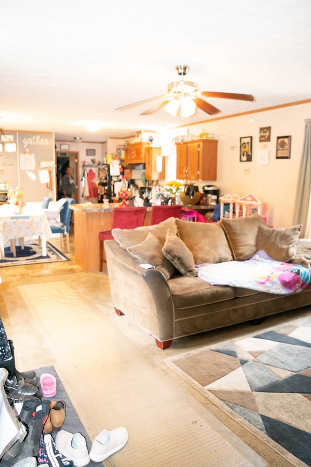 living room with ornamental molding, light hardwood / wood-style flooring, and ceiling fan