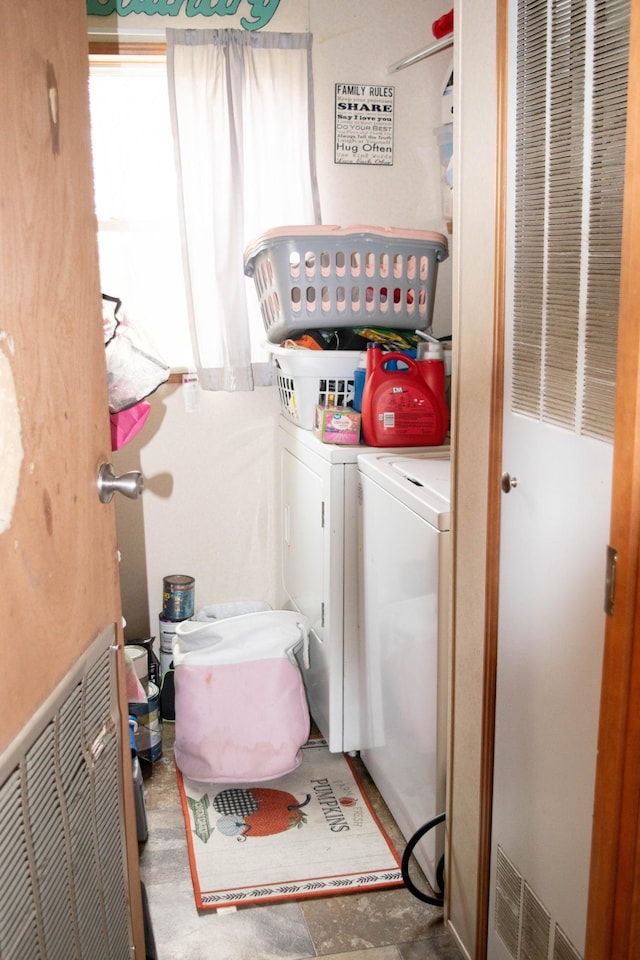 clothes washing area with visible vents, washing machine and clothes dryer, and laundry area