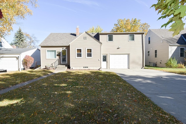 view of front of house featuring cooling unit, a front yard, and a garage