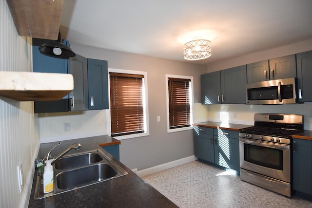 kitchen with sink, stainless steel appliances, and an inviting chandelier