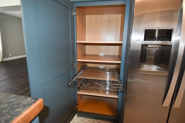 kitchen featuring dark hardwood / wood-style flooring, blue cabinets, and stainless steel refrigerator with ice dispenser