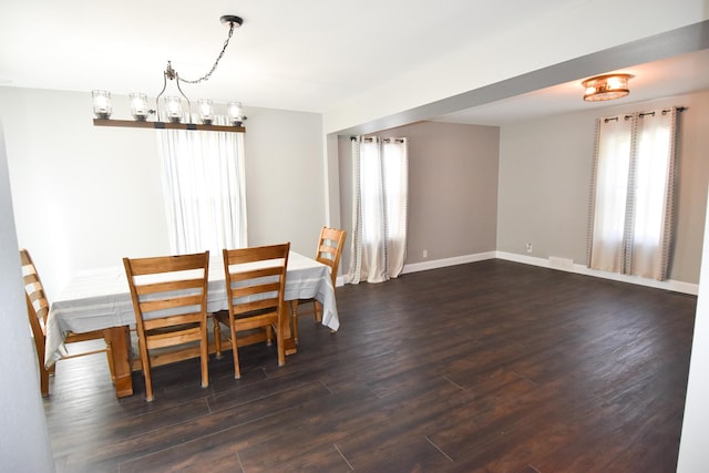 unfurnished dining area featuring a notable chandelier and dark hardwood / wood-style floors