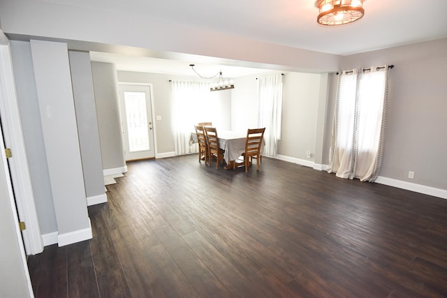 dining space with dark hardwood / wood-style floors and an inviting chandelier