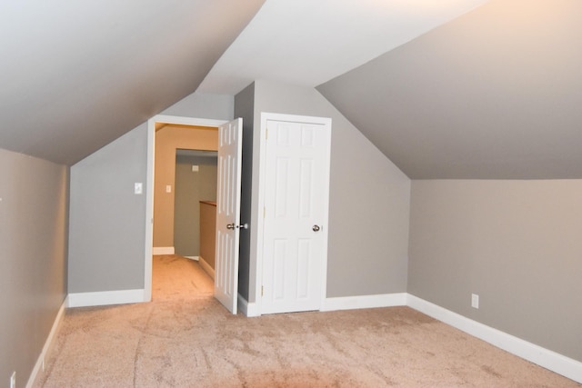 bonus room with light colored carpet and lofted ceiling