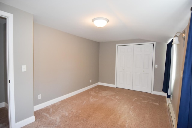 unfurnished bedroom with vaulted ceiling, carpet floors, and a closet