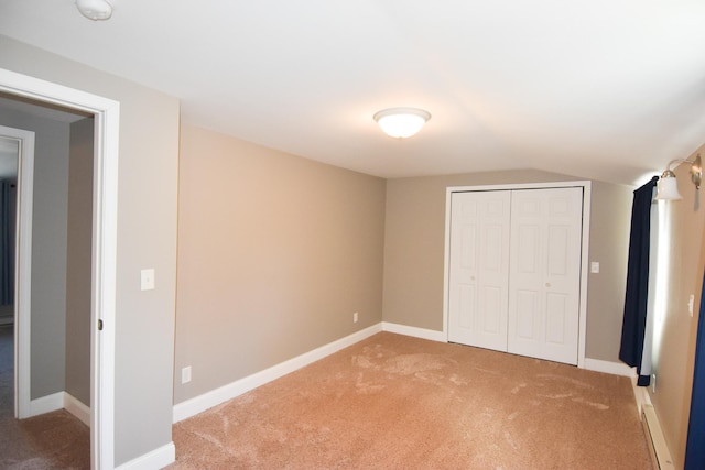 unfurnished bedroom with carpet flooring, a closet, and lofted ceiling