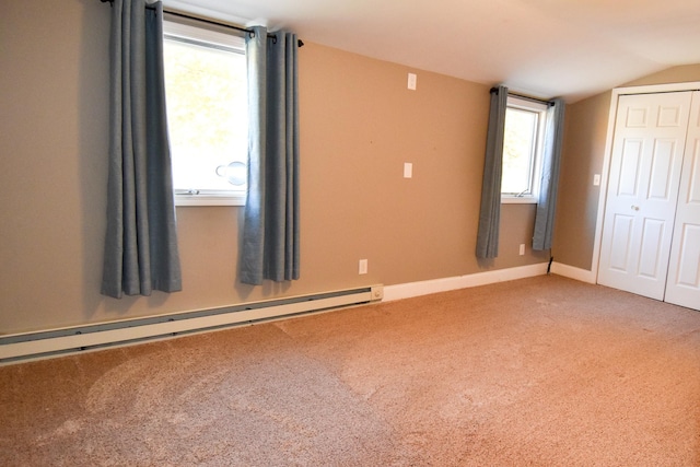 unfurnished bedroom featuring carpet flooring, a baseboard radiator, vaulted ceiling, and a closet