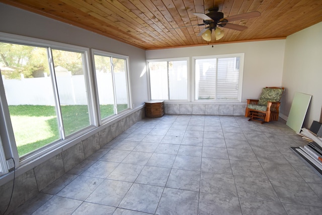 unfurnished sunroom with a wealth of natural light, wooden ceiling, and ceiling fan