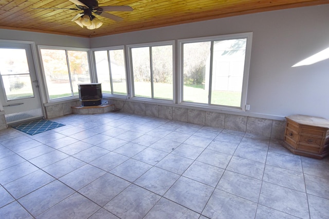 unfurnished sunroom with ceiling fan, wood ceiling, and a wood stove