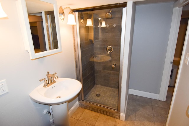 bathroom featuring tile patterned floors, a shower with shower door, and sink