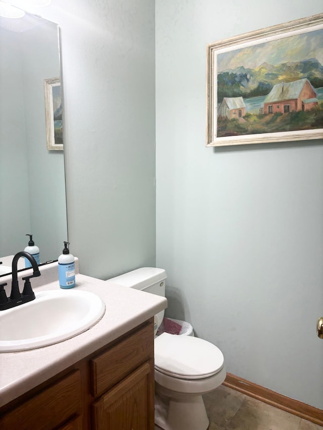 bathroom with toilet, vanity, and tile patterned floors