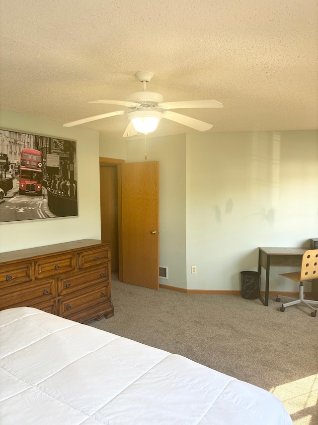 carpeted bedroom featuring a textured ceiling and ceiling fan