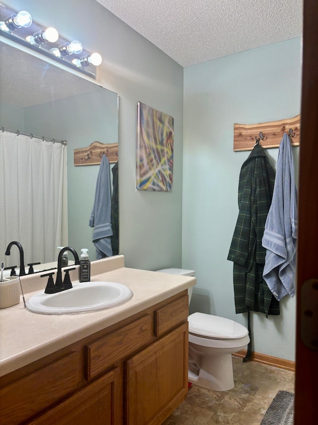 bathroom with vanity, a textured ceiling, and toilet