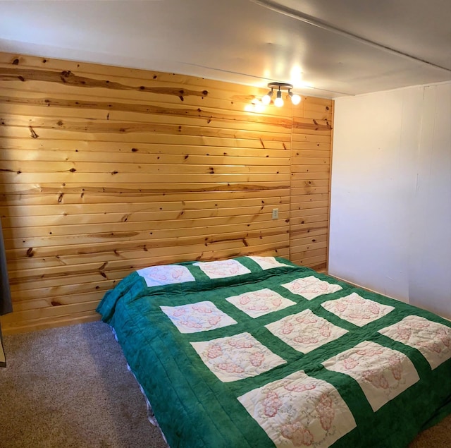 carpeted bedroom featuring wood walls