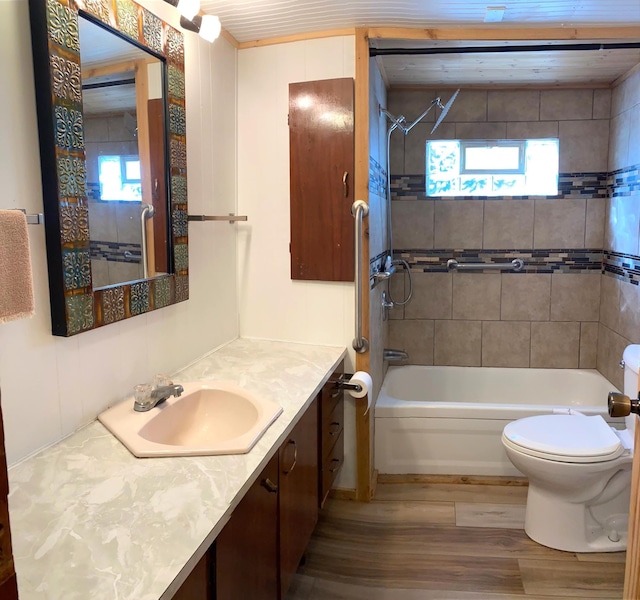 full bathroom featuring vanity, toilet, tiled shower / bath, and hardwood / wood-style flooring