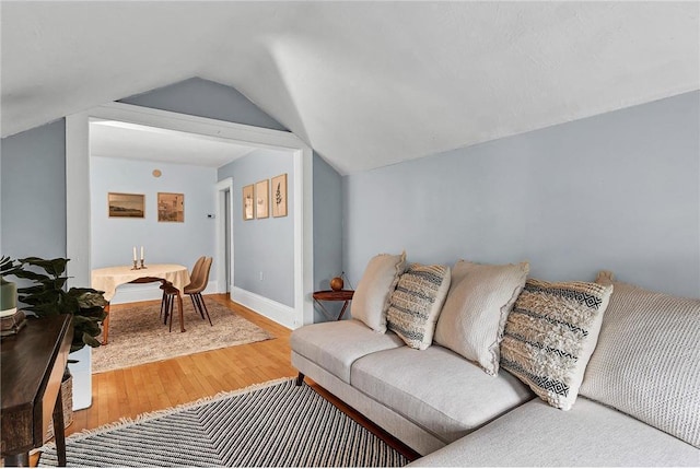 living room featuring lofted ceiling and wood-type flooring