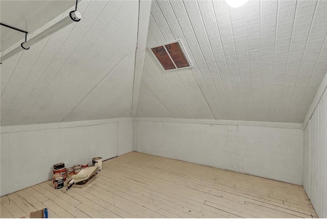 additional living space featuring lofted ceiling and light hardwood / wood-style flooring