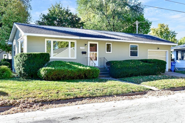 ranch-style home with a garage and a front lawn