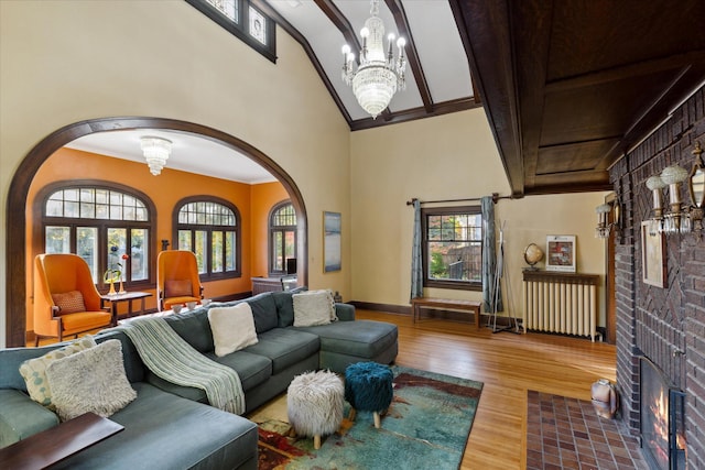 living room featuring ornamental molding, a fireplace, wood-type flooring, and plenty of natural light