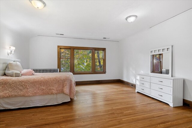 bedroom featuring light hardwood / wood-style flooring and radiator