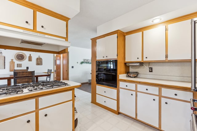 141 Lakeshore Dr, Big Lake, MN 55309 - kitchen featuring light countertops, under cabinet range hood, light floors, stainless steel gas cooktop, and white cabinets