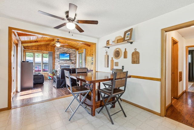 141 Lakeshore Dr, Big Lake, MN 55309 - dining area with lofted ceiling, a ceiling fan, a stone fireplace, baseboards, and light wood-style flooring