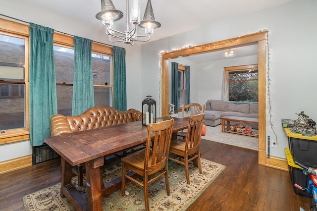 dining room with dark hardwood / wood-style flooring and a chandelier