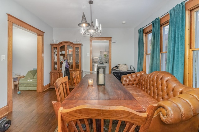 dining area with a notable chandelier and dark hardwood / wood-style floors