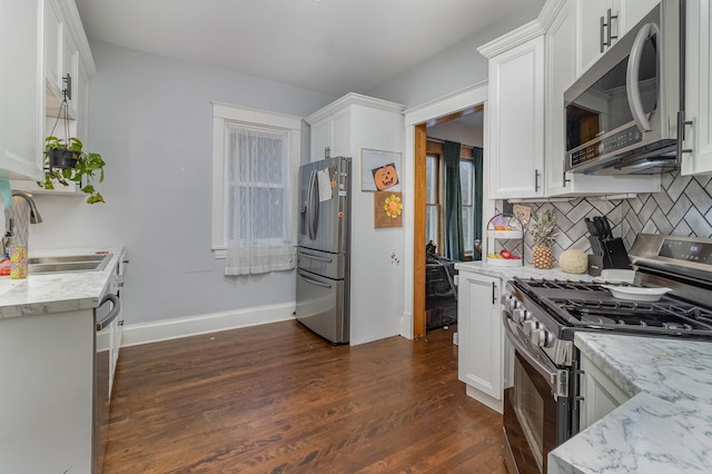 kitchen featuring sink, white cabinets, appliances with stainless steel finishes, light stone counters, and dark hardwood / wood-style flooring