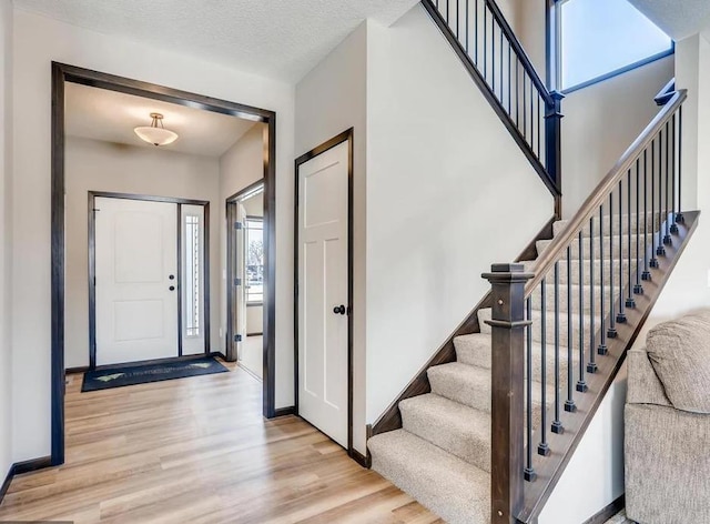 foyer with a textured ceiling and light wood-type flooring