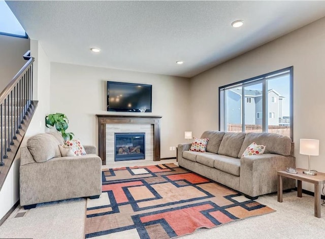 living room with carpet, a textured ceiling, and a fireplace