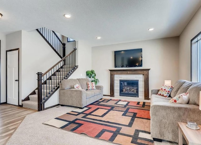 living room featuring a textured ceiling, hardwood / wood-style flooring, and a fireplace