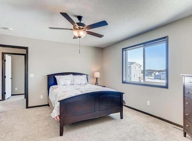 carpeted bedroom with a textured ceiling and ceiling fan