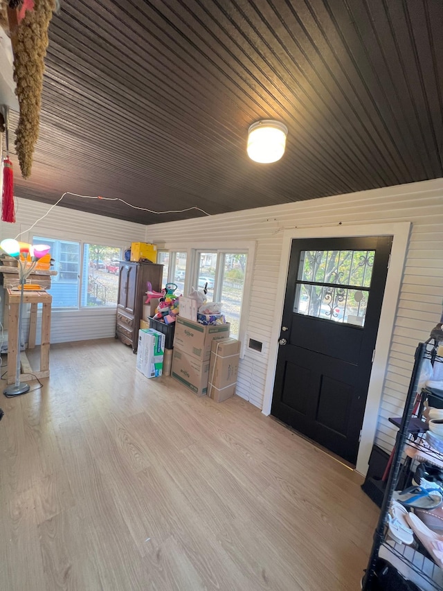 entrance foyer featuring wooden walls, light hardwood / wood-style flooring, and wood ceiling