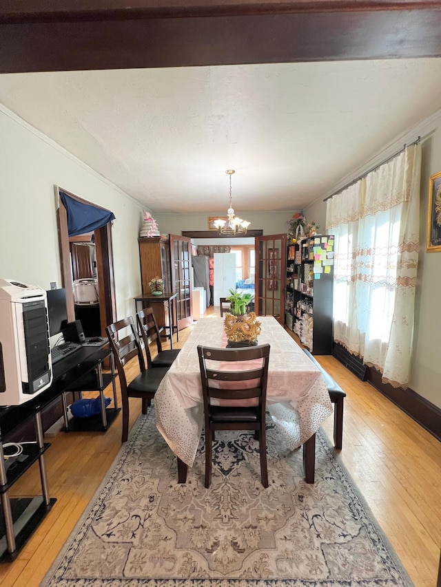 dining space with a notable chandelier and light wood-type flooring