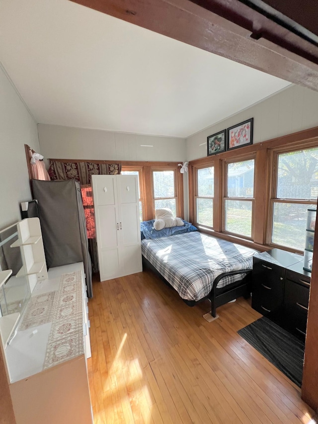 bedroom featuring stainless steel fridge and light hardwood / wood-style floors