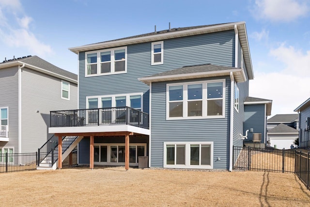 back of house with a fenced backyard, stairs, and a deck